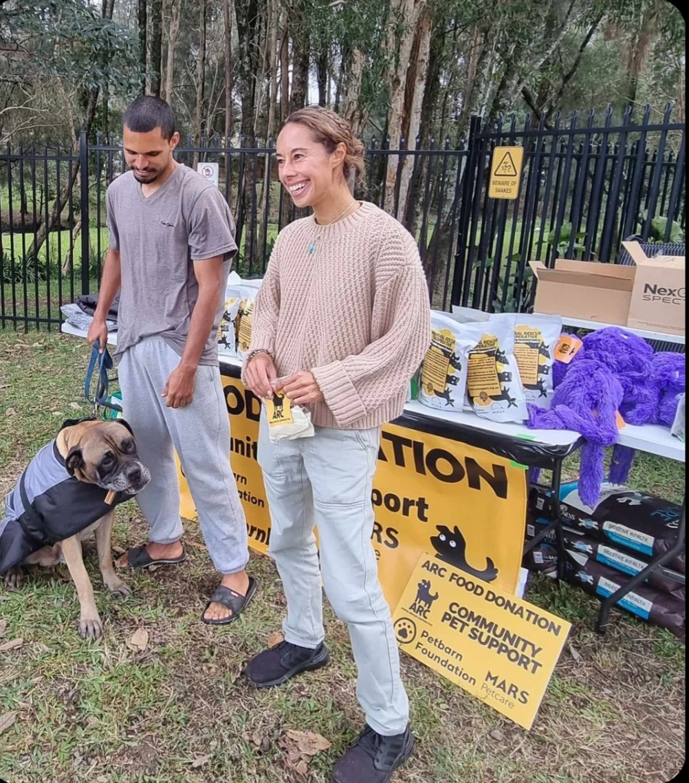 People and a dog beside donated supplies at Kempsey