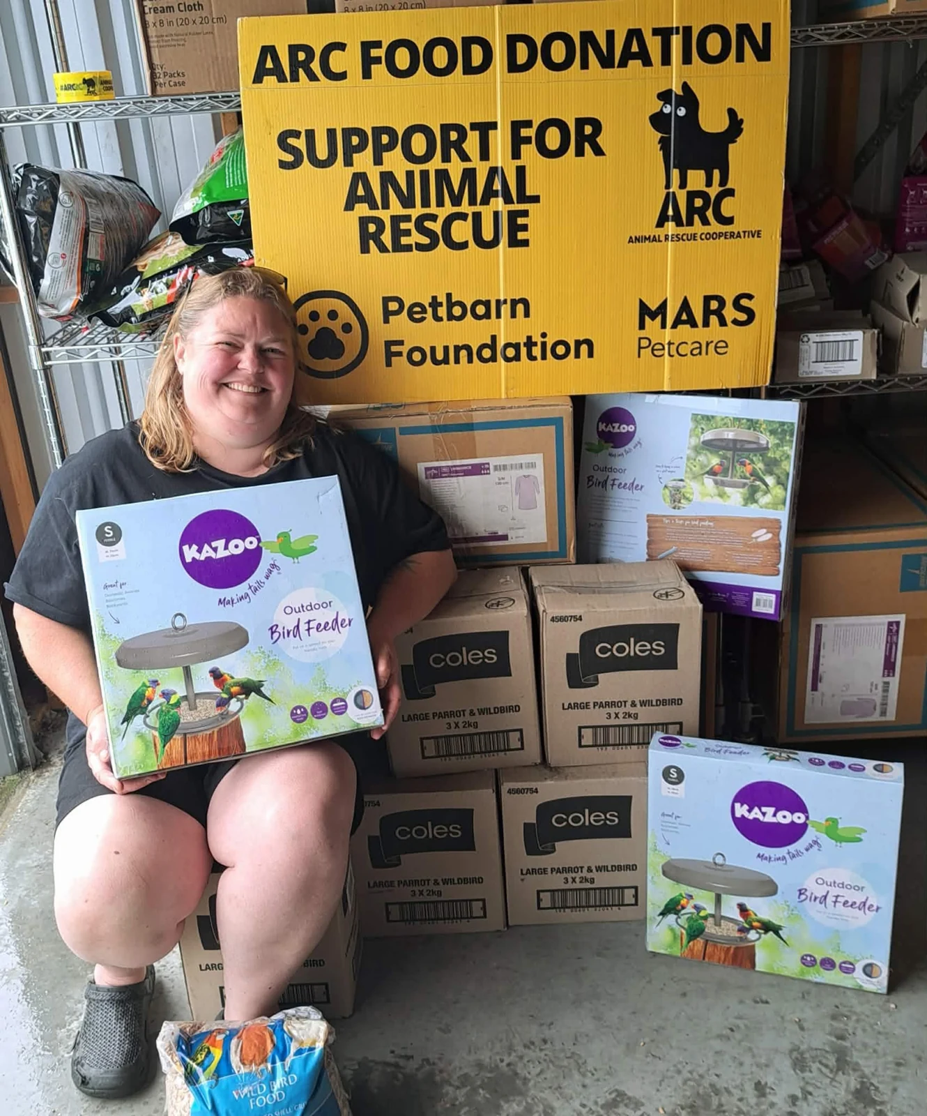 A volunteer with donated pet food at the Tasmania Hub