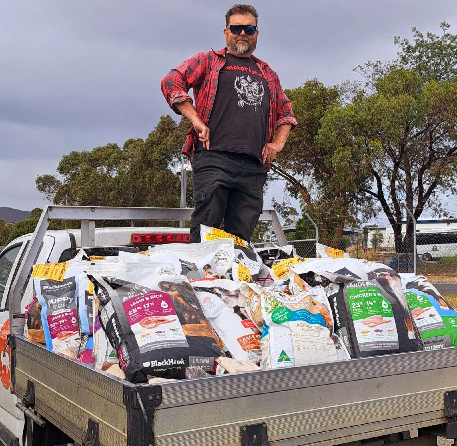 A volunteer standing beside a ute filled with supplies